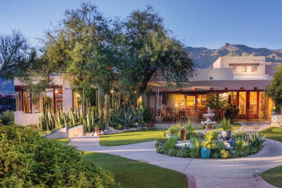 Modern residential home with terracotta exterior, desert landscaping, and mountain backdrop