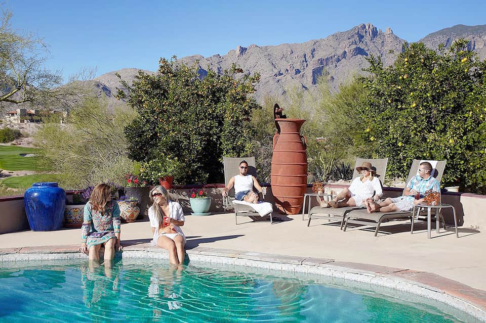 Desert resort pool with families, mountain backdrop and southwestern décor