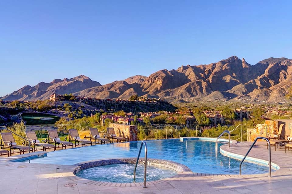 Resort pool with spa and mountain views, lounge chairs, desert landscape