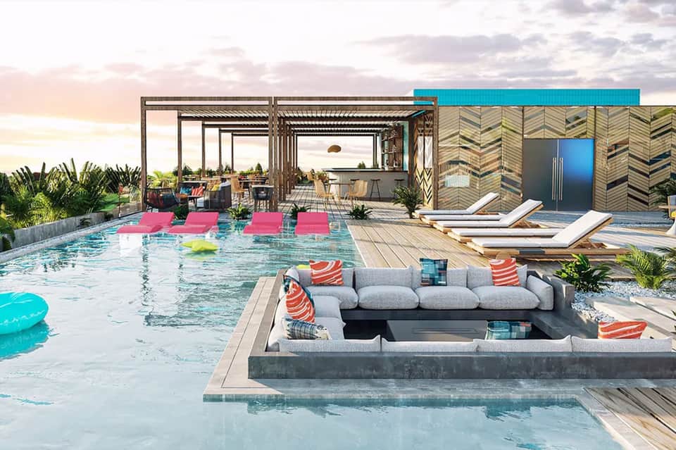 Modern resort pool with sunken lounge area, pink floats, and contemporary architecture