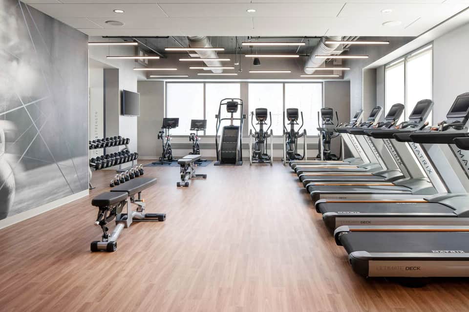 Modern fitness center with treadmills, dumbbells, and exercise equipment