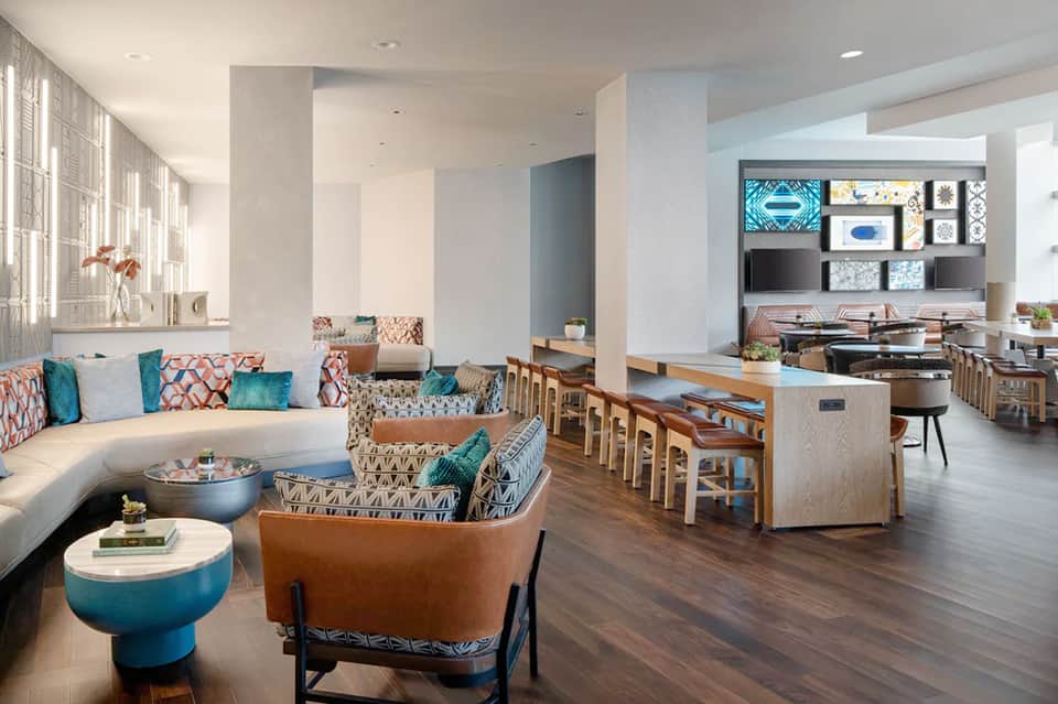 Modern resort suite with contemporary furniture, geometric patterns, kitchen, and living area