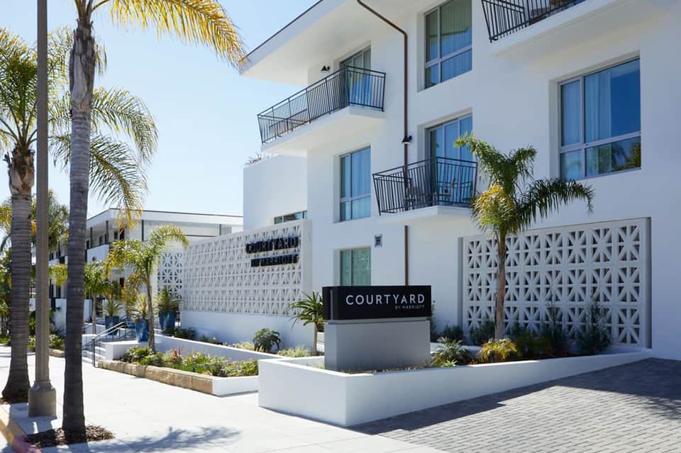 Modern white Courtyard hotel building with decorative screens and palm trees