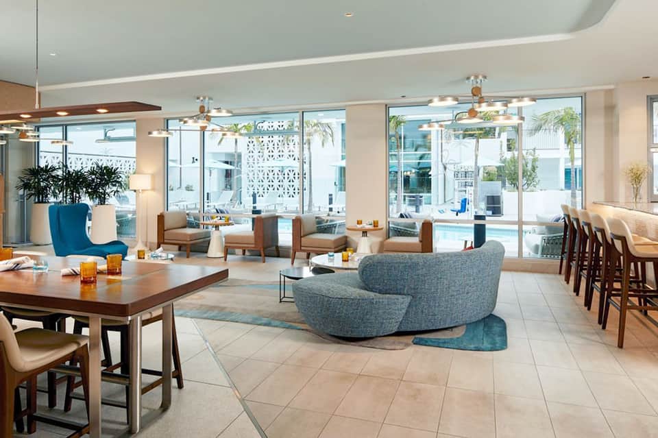 Spacious resort lounge with contemporary furniture, pool views, and floor-to-ceiling windows