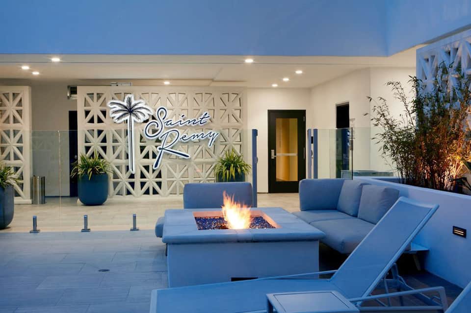 Modern resort courtyard with fire pit, blue seating, and geometric architectural details