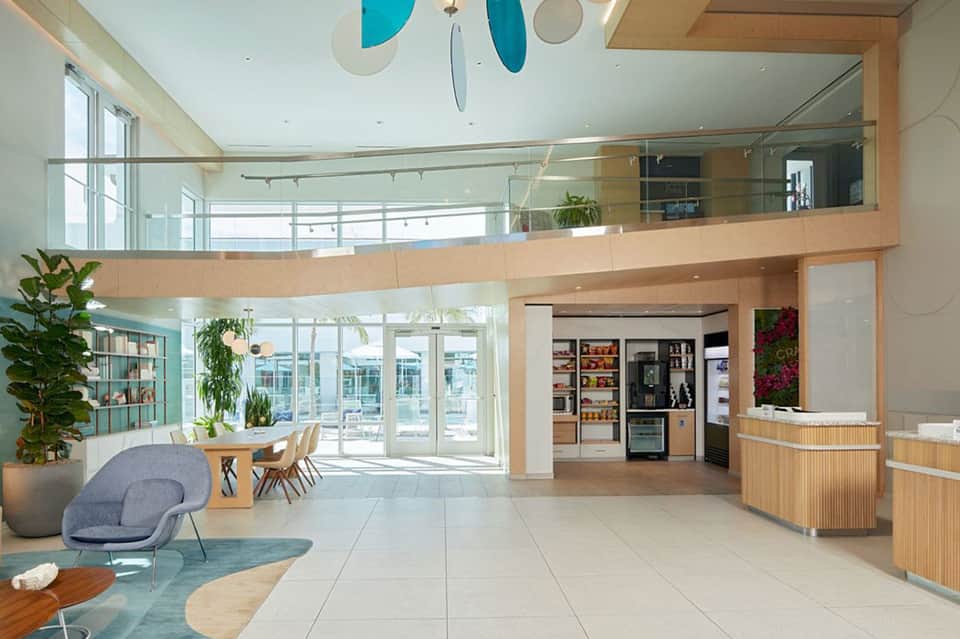 Modern spa reception area with two-story wood-trimmed interior and water views