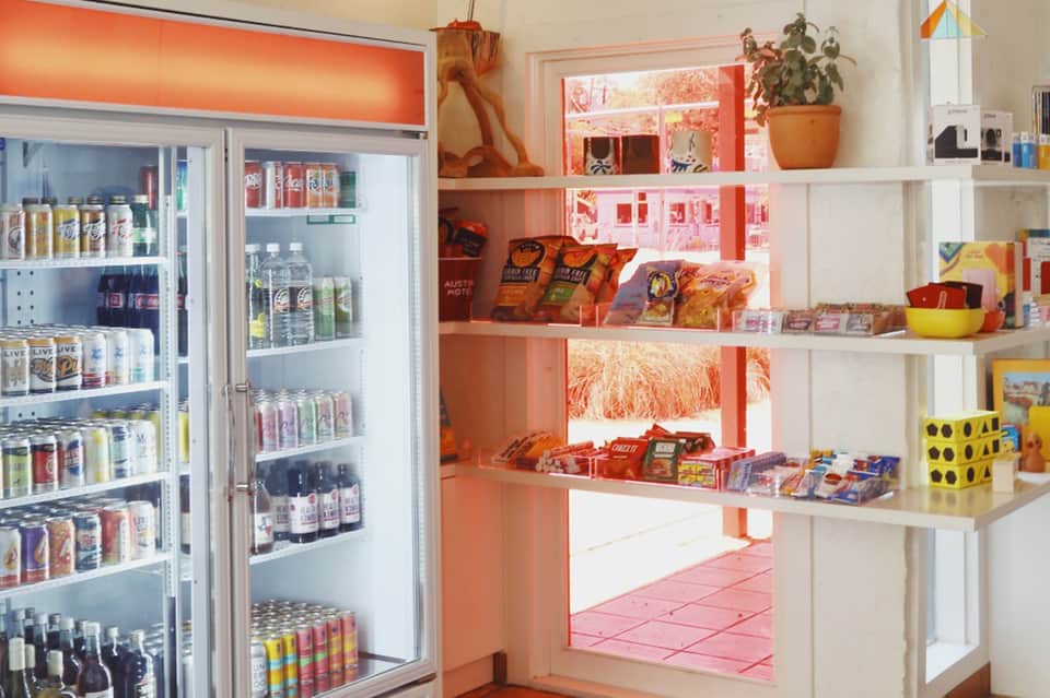Bright retail shop interior with refrigerated beverages and colorful product shelving
