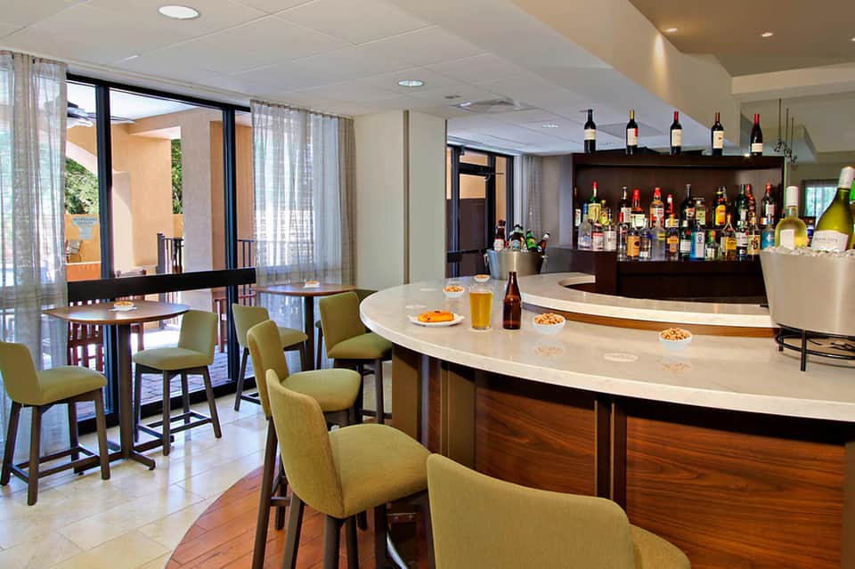 Contemporary resort bar and lounge with seating, full bar, and patio access