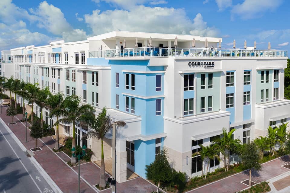 Contemporary Courtyard Hotel building with blue and white facade and rooftop deck