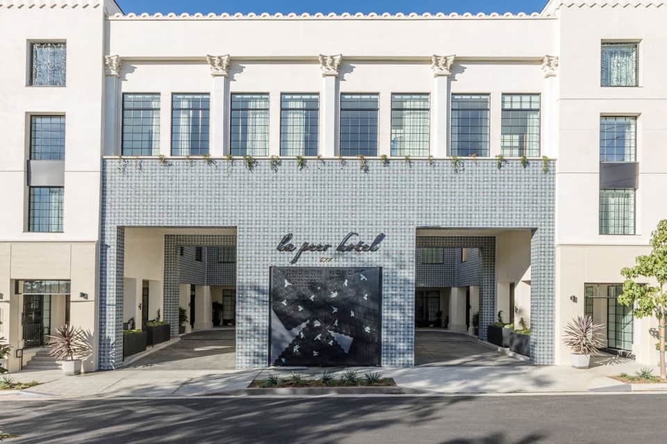 Historic hotel facade with white tiled entry, ornamental columns, and symmetrical design