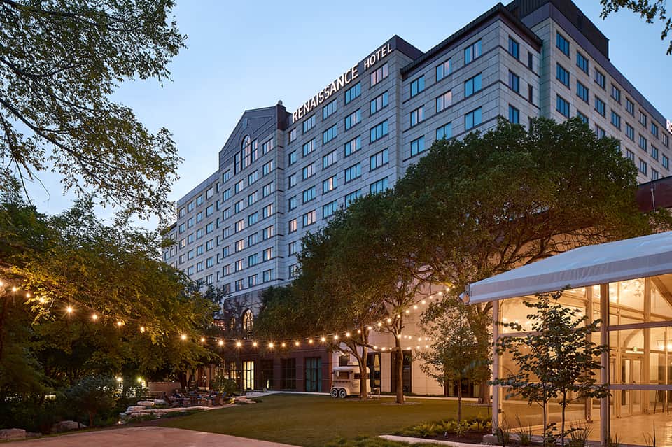 Evening courtyard at Renaissance Hotel with illuminated trees and modern pavilion structure