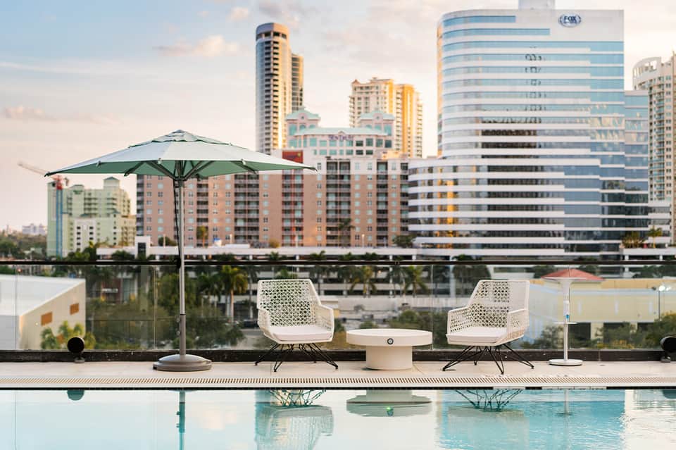 Modern rooftop lounge area with infinity pool and city skyline backdrop