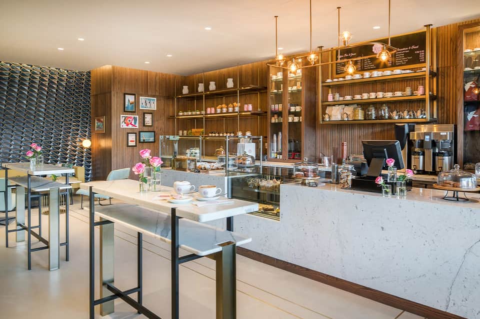 Luxury spa reception area with wooden walls, shelving, pendant lighting, and marble countertops