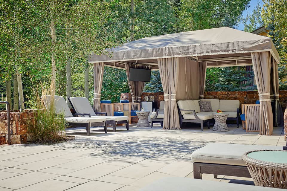 Outdoor patio with large covered gazebo, lounge furniture, and tree-lined setting