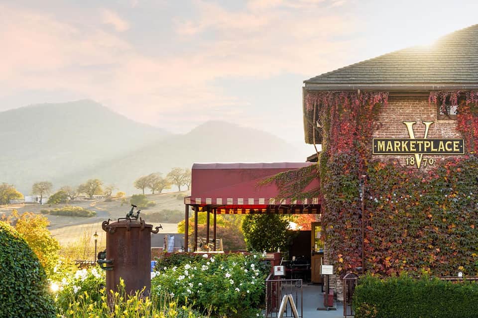 Historic marketplace building with ivy-covered walls and mountain valley views