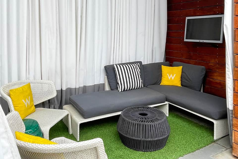 Contemporary lounge with gray sectional sofa, yellow accents, and large windows