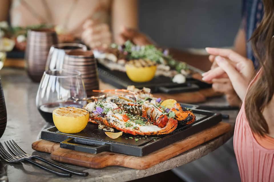 Grilled lobster and seafood dishes with drinks at fine dining table