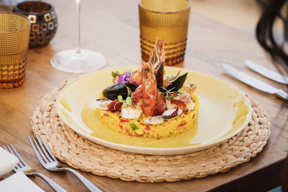 Elegant plated seafood dish with shrimp and mussels on saffron risotto