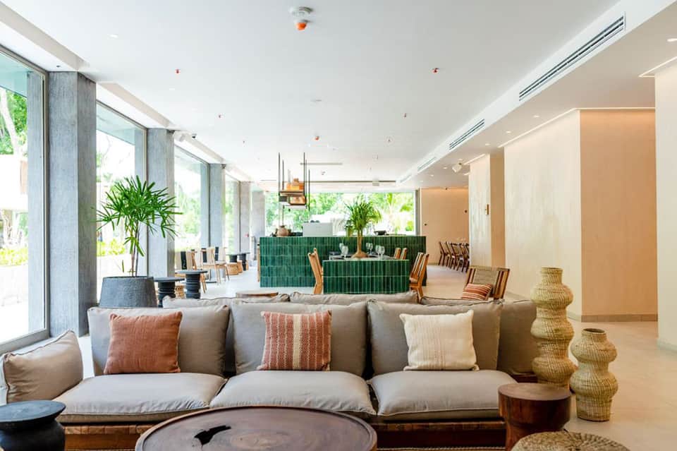 Modern hotel lobby lounge with neutral tones, comfortable seating, and large windows