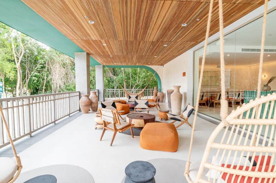 Modern deck with swing chairs, lounge seating, and turquoise-accented architectural design