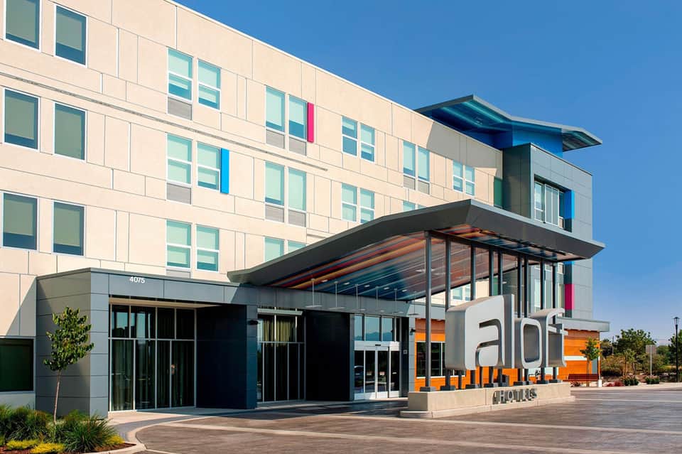 Modern hotel building entrance with orange signage and contemporary architecture