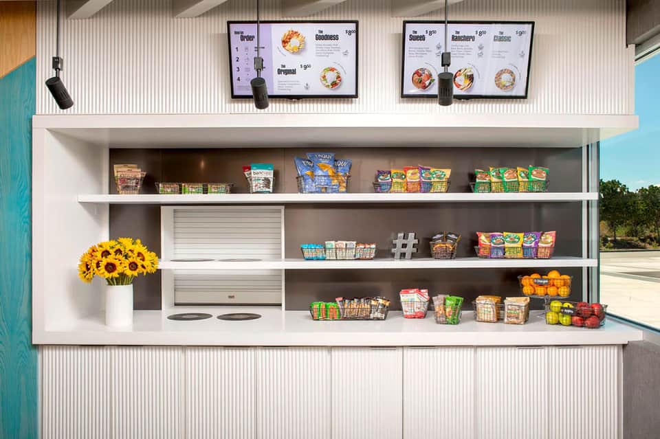 Contemporary resort concession stand with digital menu boards and snack display shelving