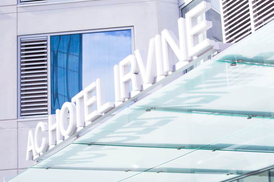 Modern hotel building exterior with white 'Acormarine' signage and glass canopy