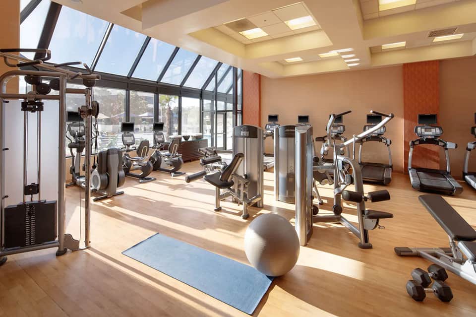 Bright fitness center with cardio equipment, treadmills, and panoramic windows