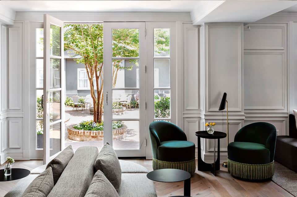 Elegant living room with floor-to-ceiling glass doors opening to courtyard garden view