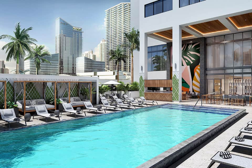 Modern rooftop pool with turquoise water, sun loungers, wooden pergolas, and city skyline views