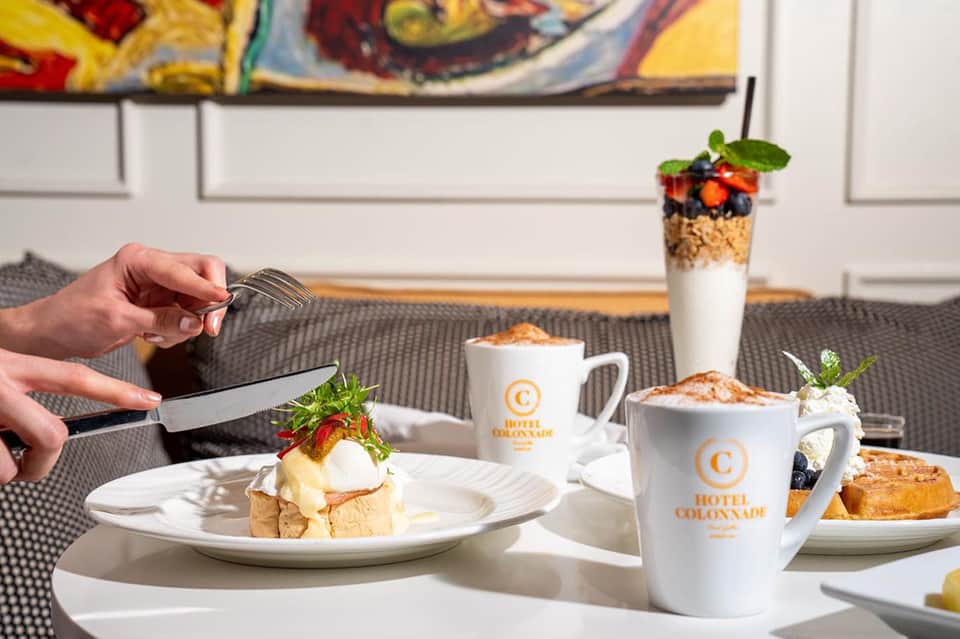 Fine dining plated dessert with cream, berries, and pastry on white plate at Hotel Colonnade restaurant