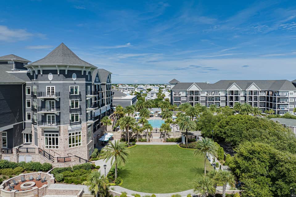 Aerial view of luxury resort complex with Victorian-style architecture, manicured lawns, and pool area