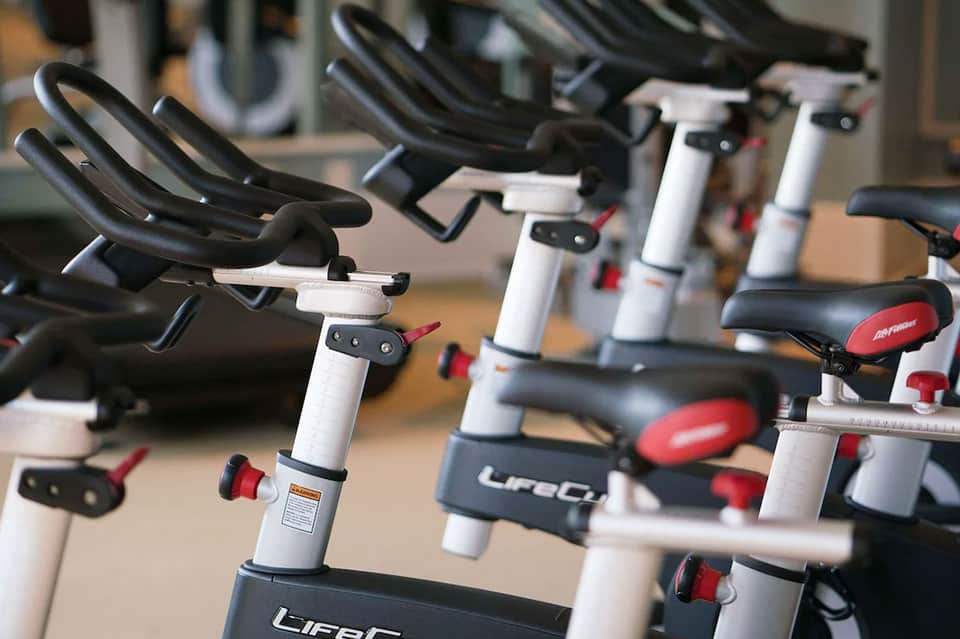 Hotel fitness studio with stationary bikes and gym equipment in rows