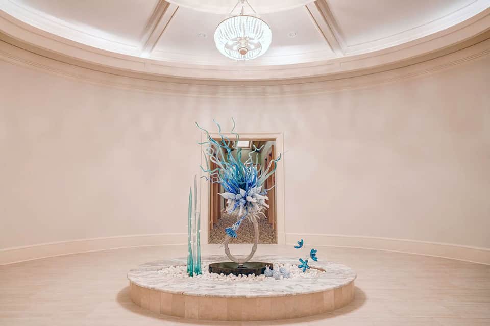 Elegant circular lobby with domed ceiling and blue glass sculptural centerpiece