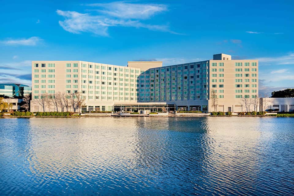 Multi-story modern hotel building reflecting in calm waterfront