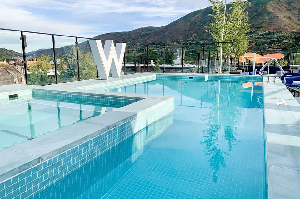 Modern W resort pool with mountain views, glass railings, and spa facilities