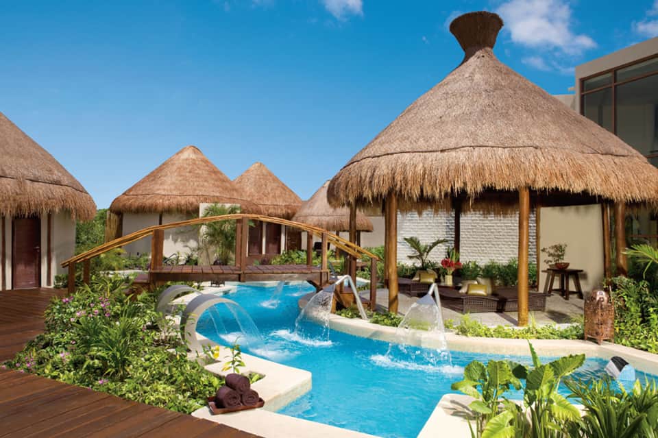 Luxury overwater bungalows with thatched roofs and private pool features