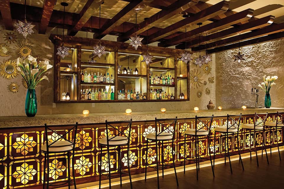 Upscale bar with decorated ceiling beams and ornate patterned railings