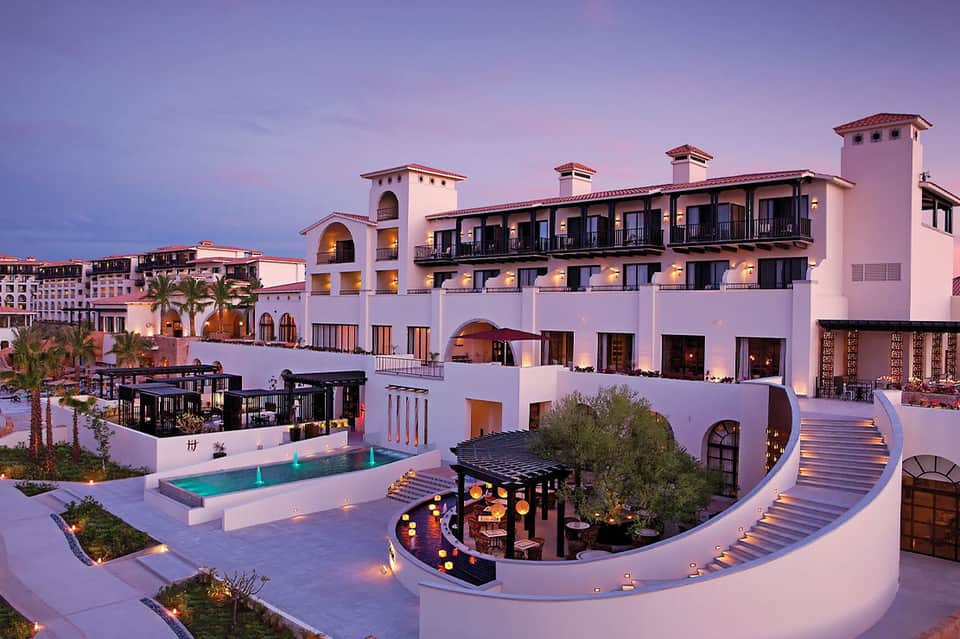 Luxurious resort courtyard at twilight with pool, architecture, and ambient lighting
