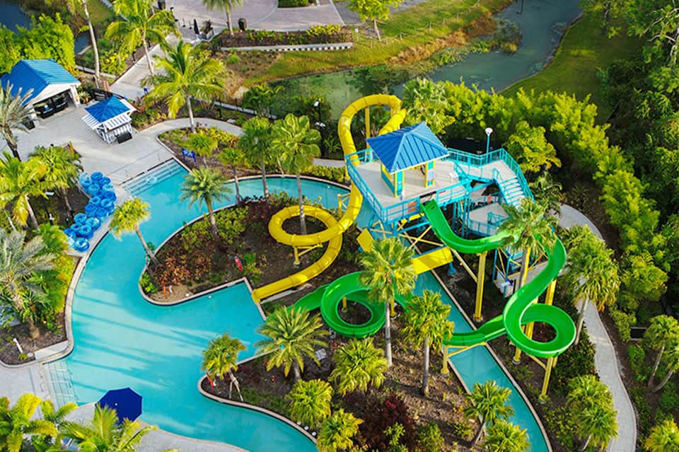 Aerial view of resort with colorful water slides, pools, and tropical landscaping