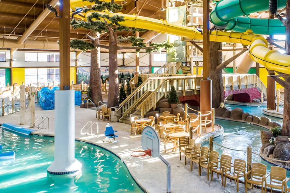 Indoor water park with multiple pools, water slides, and tropical themed architecture