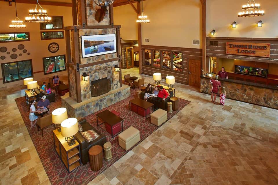 Hotel lobby interior with fireplace, wooden beams, comfortable seating, and rustic-modern decor