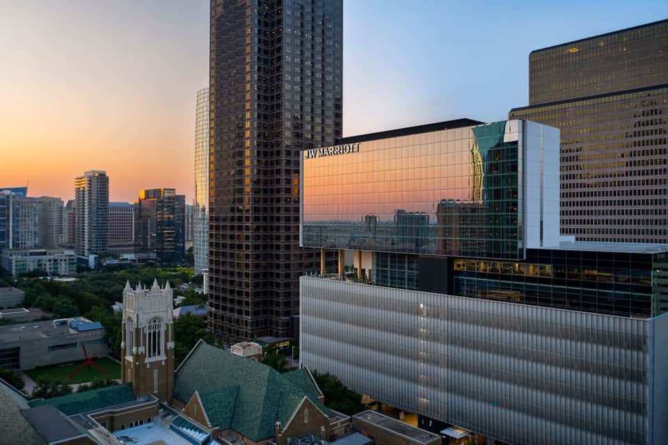 Downtown skyline view at sunset with Marriott hotel sign and city buildings illuminated in golden hour