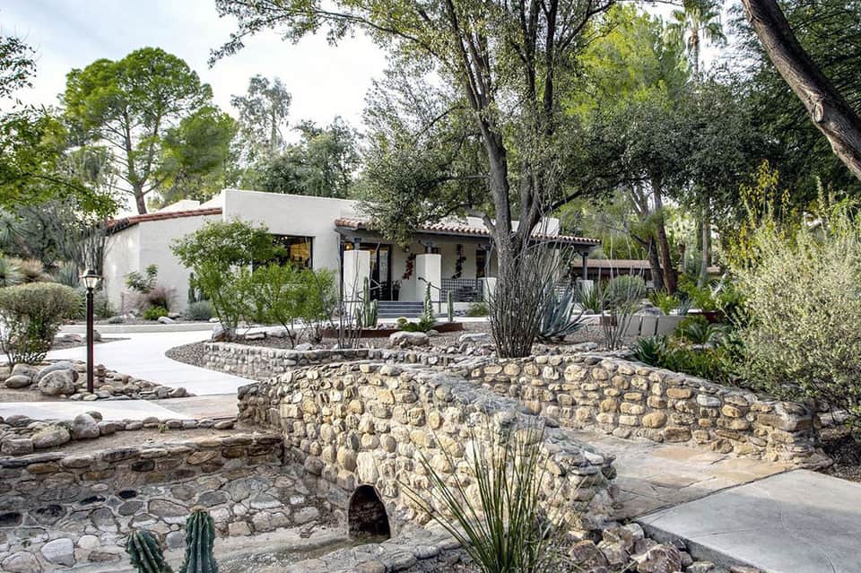 Rustic desert resort courtyard with stone architecture, native landscaping, and white buildings