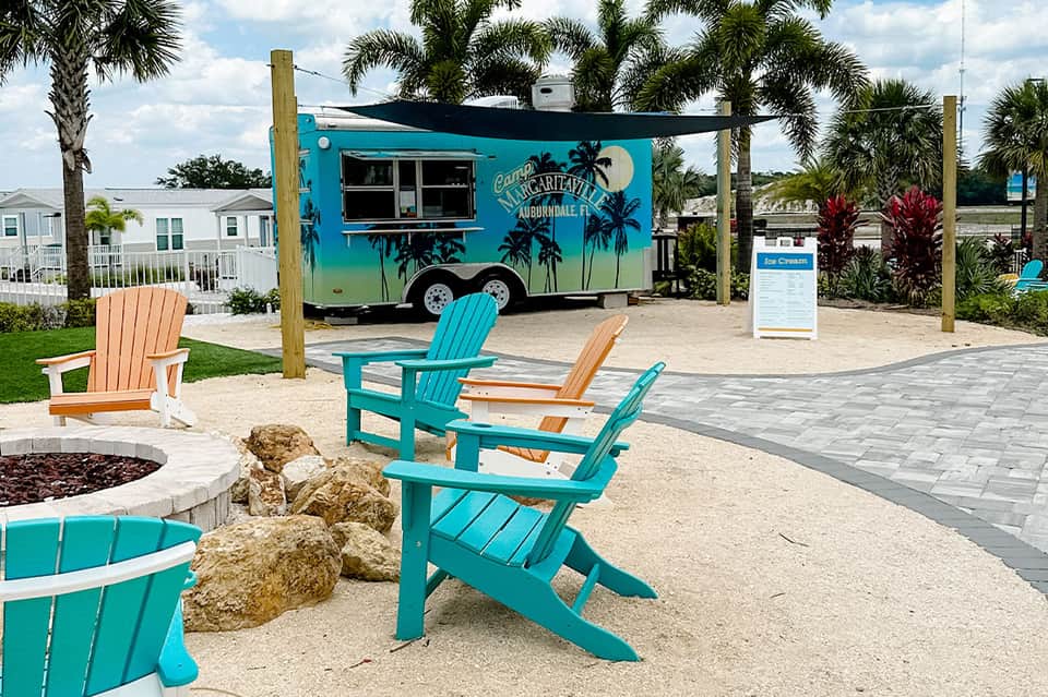Turquoise Adirondack chairs near food truck at beach resort in Auburndale, Florida