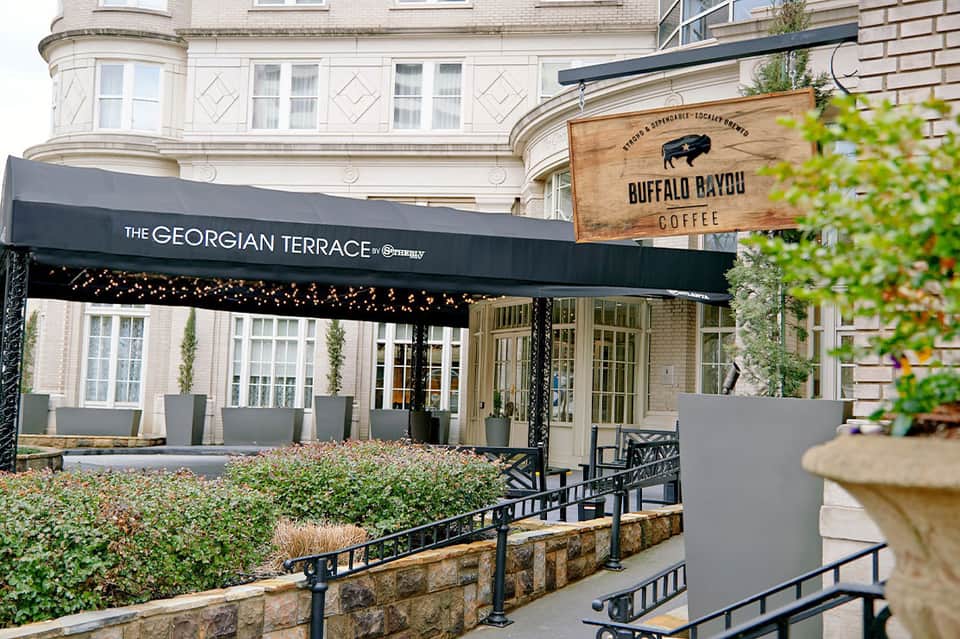 Outdoor café terrace with awning, stone patio, and historic building architecture