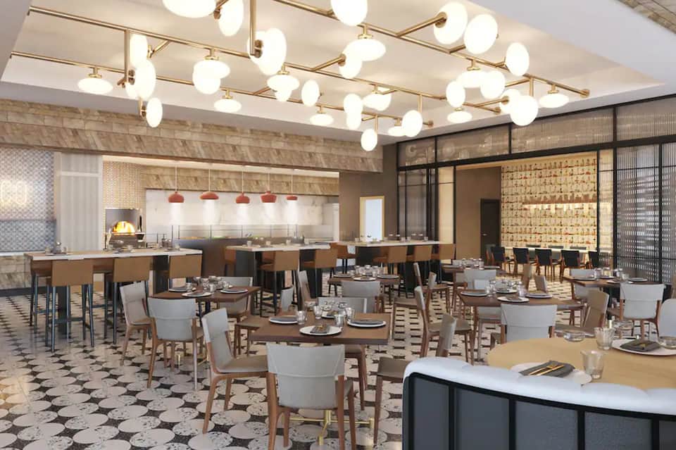 Contemporary restaurant dining room with patterned flooring, hanging globe lights, and open kitchen