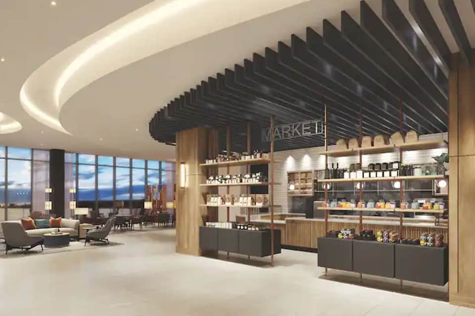Contemporary hotel lobby with curved ceiling, market marketplace counter, and ocean views