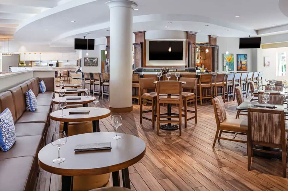 Modern hotel restaurant and bar with wood accents, leather banquettes, and contemporary furnishings