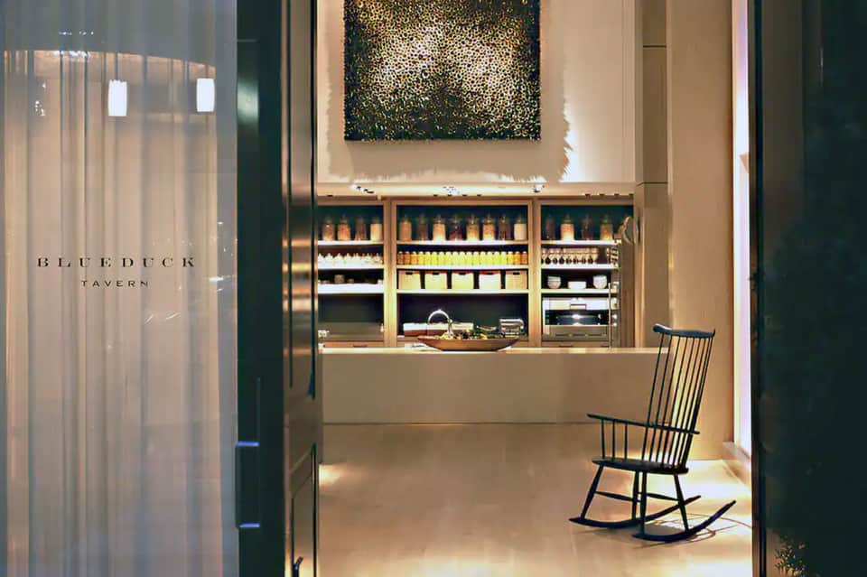 Blueduck Tavern entrance with wooden display shelving of premium beverages and seating area